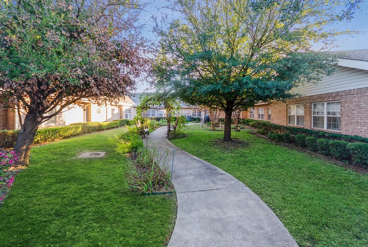 A landscaped garden with a winding pathway in an apartment complex.