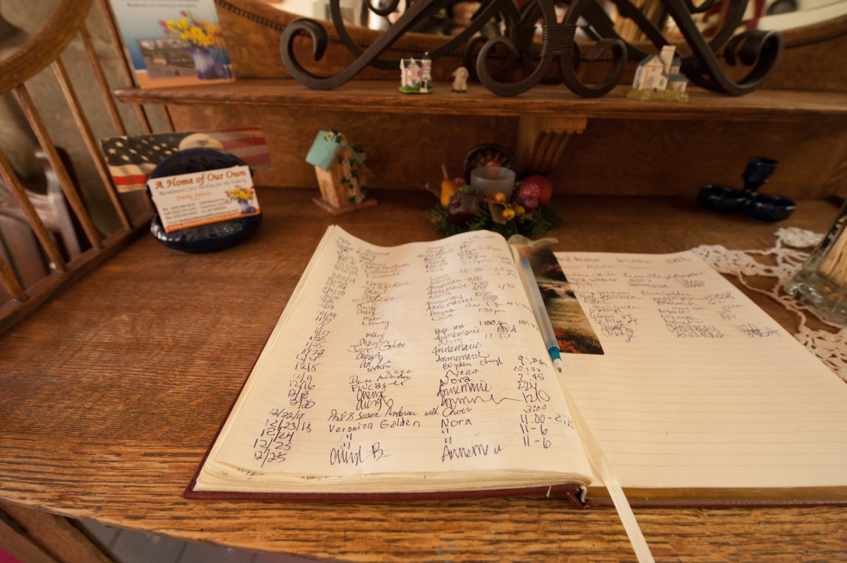An open journal on a wooden desk, filled with handwritten notes.