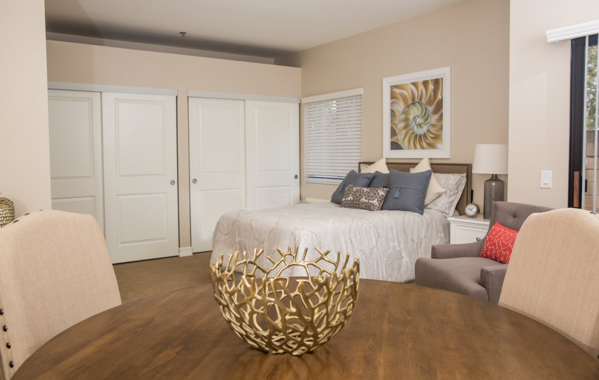 A cozy and stylishly designed bedroom featuring a comfortable bed, decorative artwork, and modern furnishings.
