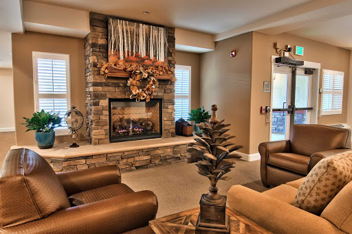 A cozy living room featuring a stone fireplace, comfortable seating, and decorative elements for a warm ambiance.