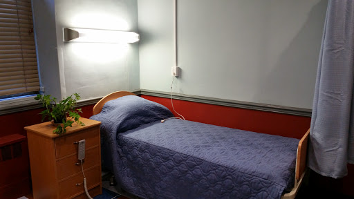 A simple bedroom featuring a single bed and bedside table.