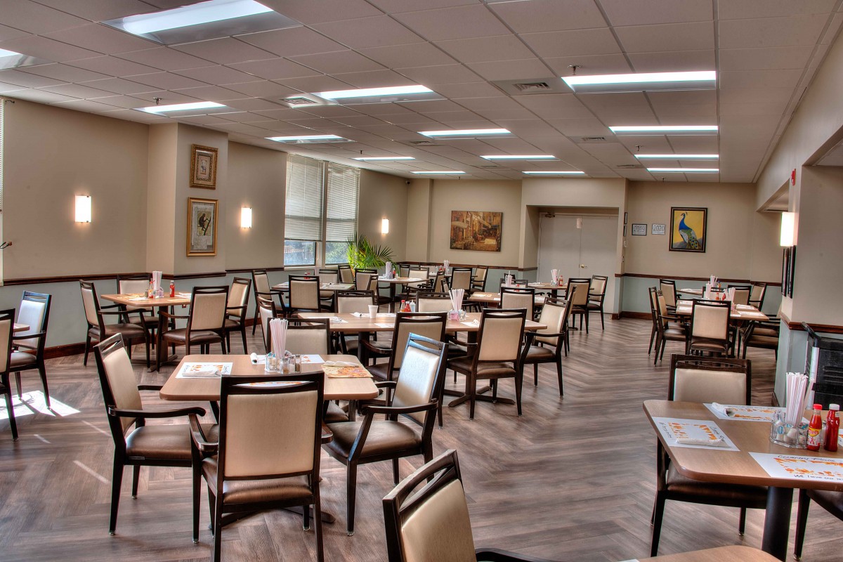 An empty dining room with neatly arranged tables and chairs.