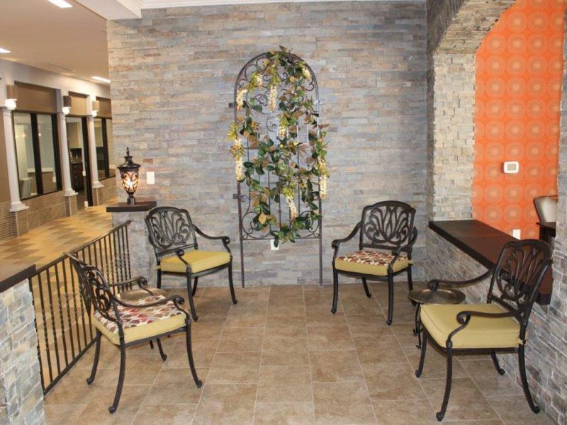 A cozy patio with iron furniture and decorative plants on the wall.