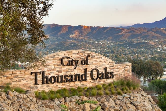 Welcome sign at the entrance to the City of Thousand Oaks, with scenic mountain backdrop.