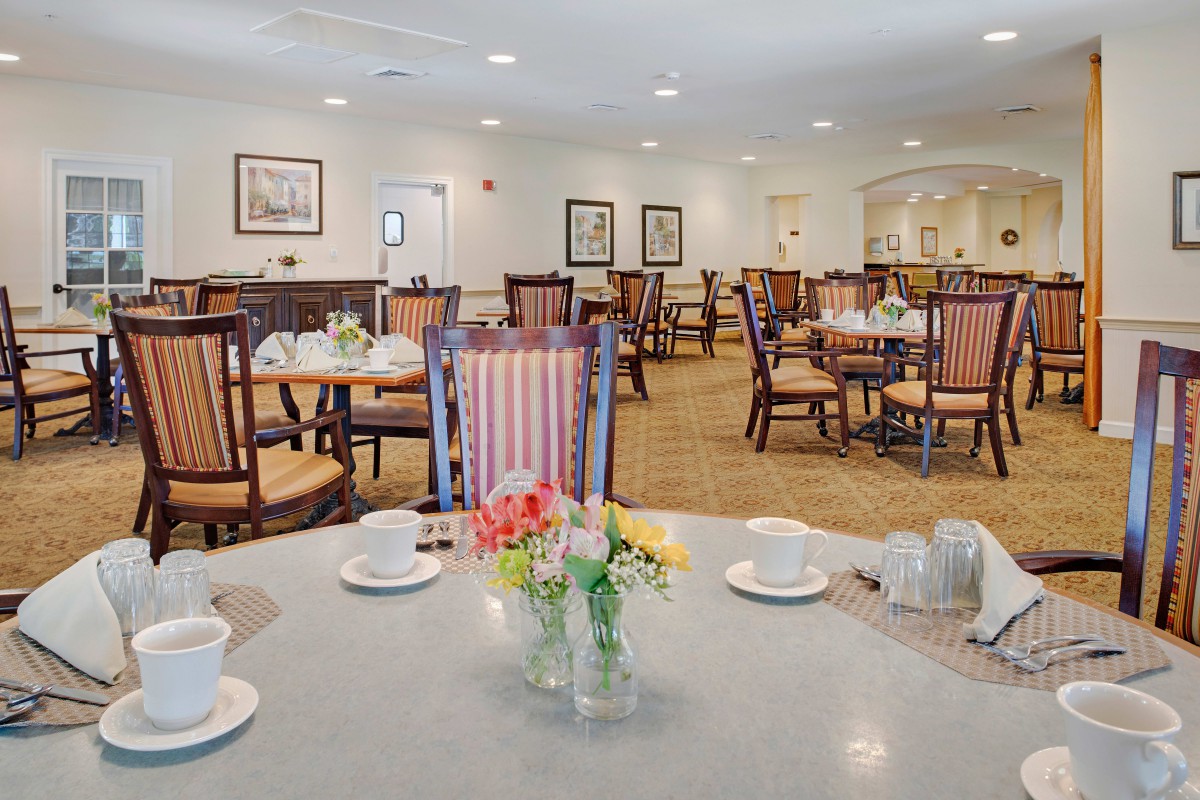 An elegant dining room with neatly arranged tables and chairs, featuring a warm and welcoming ambiance.