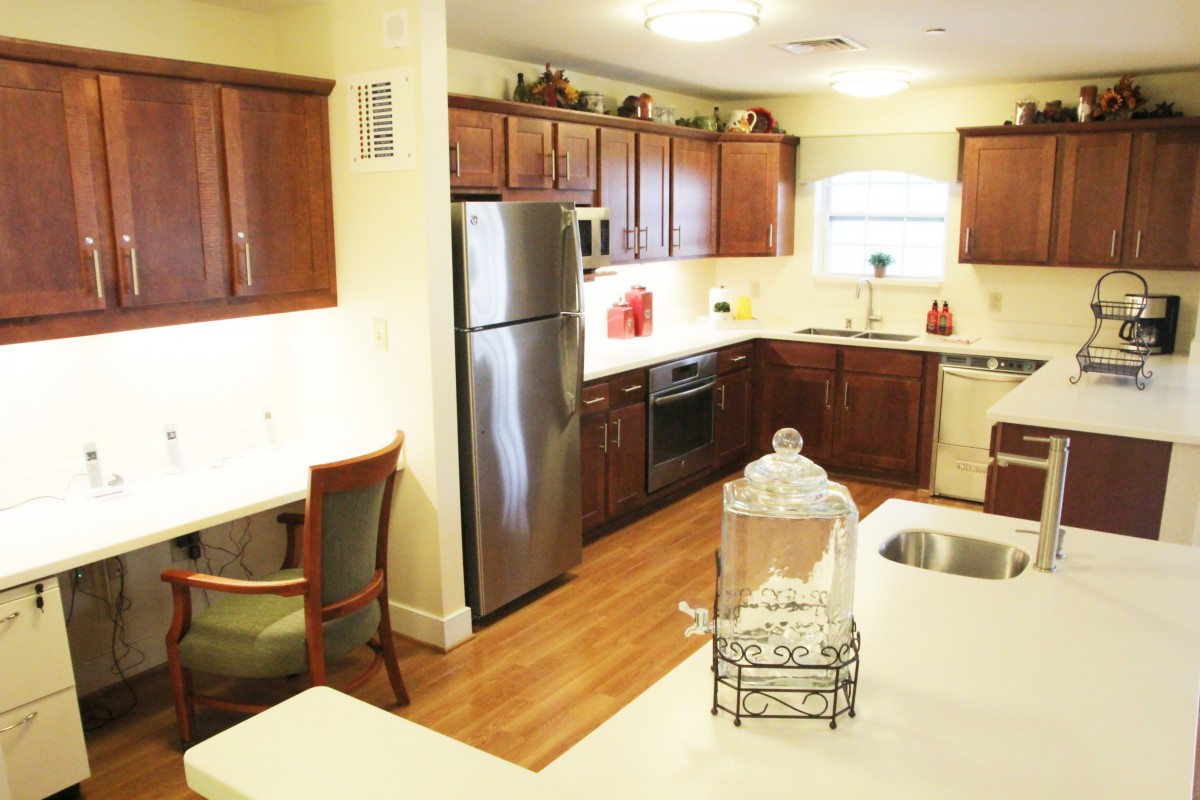 A modern kitchen interior with stainless steel appliances and wooden cabinets.
