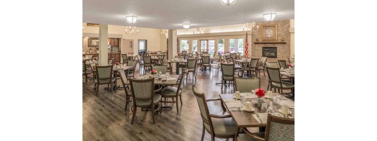 A spacious and elegantly decorated dining area with neatly arranged tables and chairs.