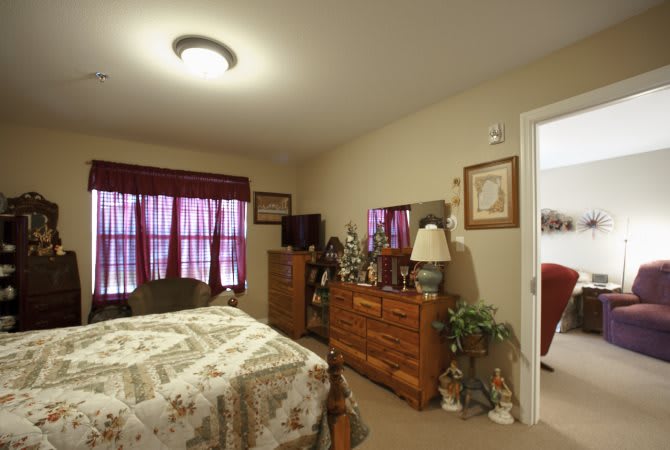 A cozy bedroom with a bed, dresser, and television.