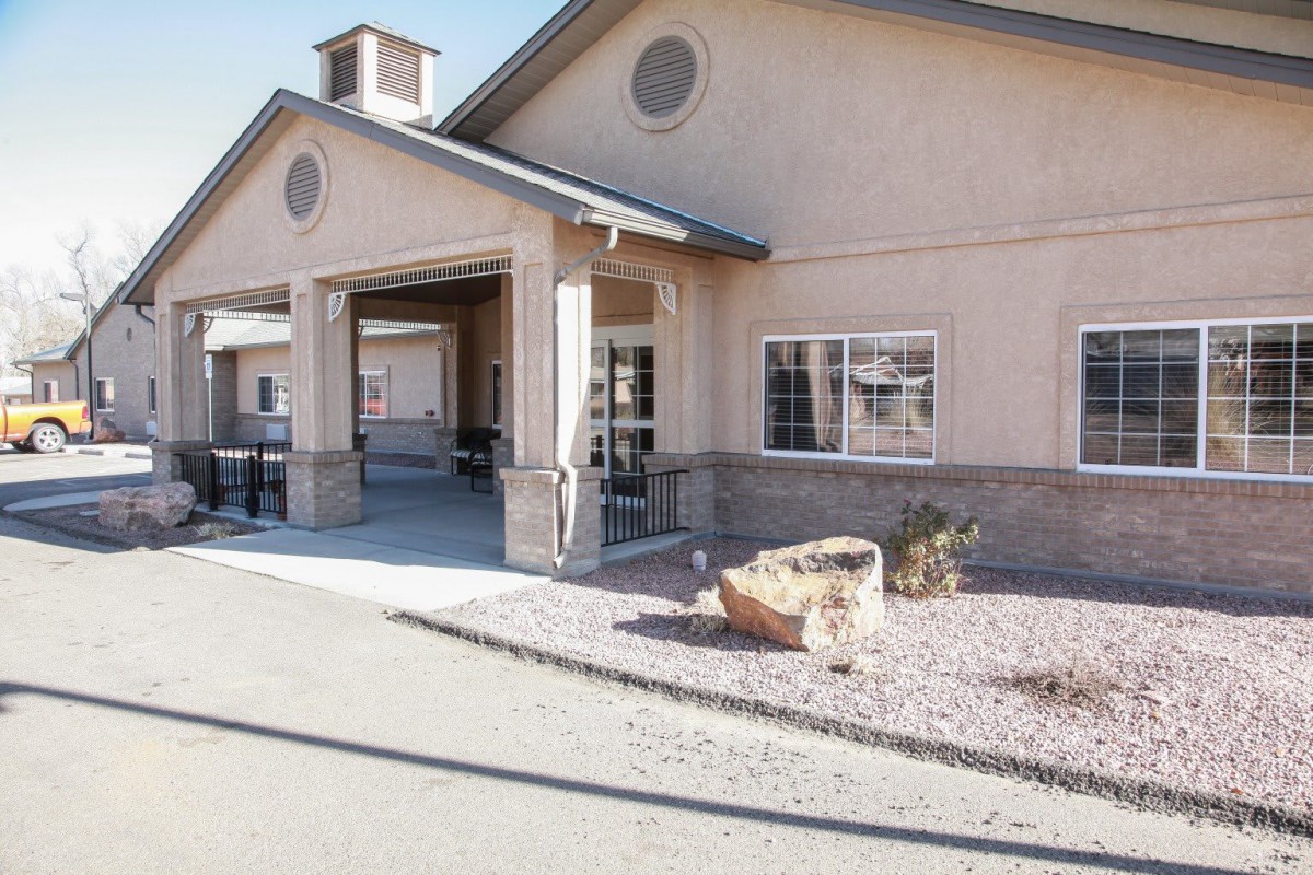 Front view of a building entrance with a driveway, captured during the daytime.