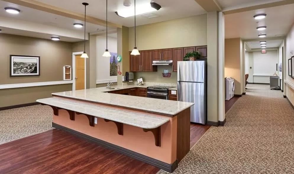 A modern kitchen with a spacious countertop, pendant lights, and stainless steel appliances.