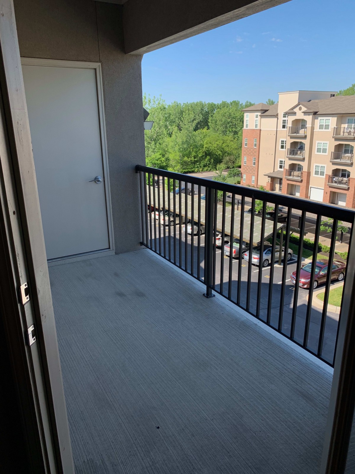 A sunny apartment balcony with a view of neighboring buildings.