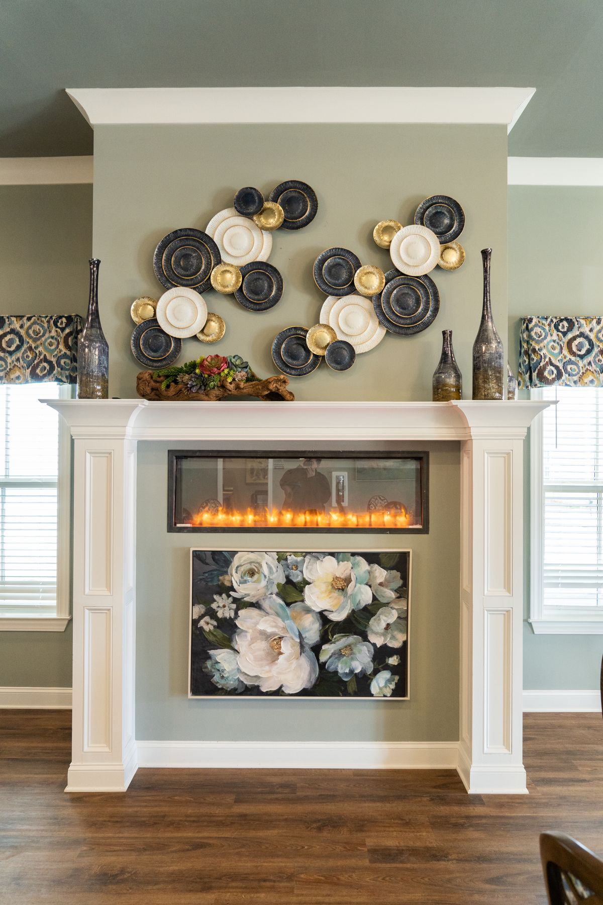 A stylish fireplace with modern wall art and floral decorations.