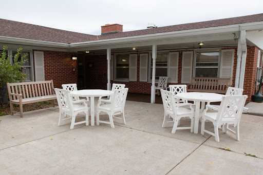 A serene outdoor seating area featuring white tables and chairs, perfect for social gatherings.
