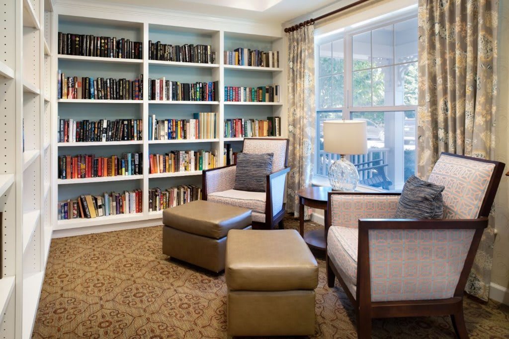 A cozy reading area with armchairs and bookshelves filled with books.
