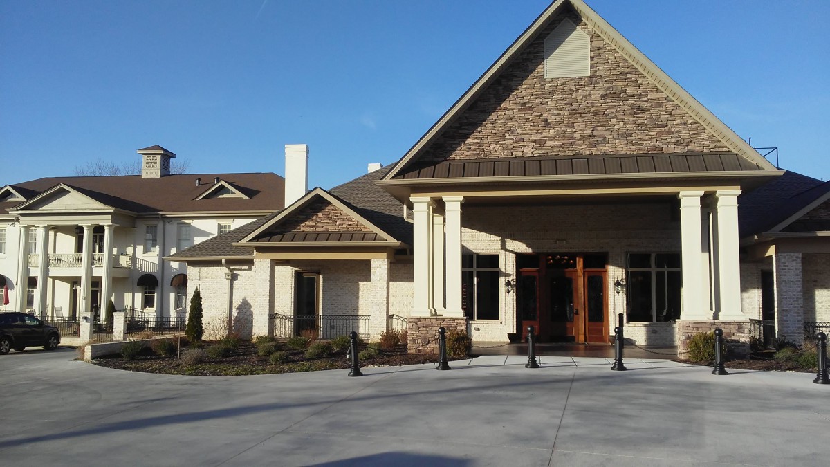 A residential building with a pitched roof and landscaped entrance.