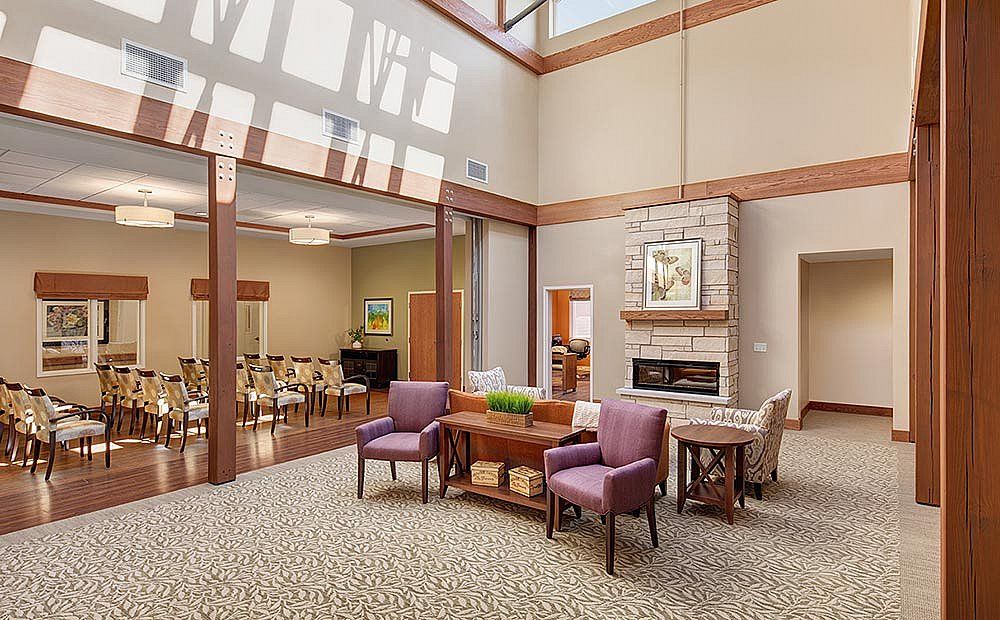 A cozy lobby with seating arrangements, natural lighting, and a fireplace.