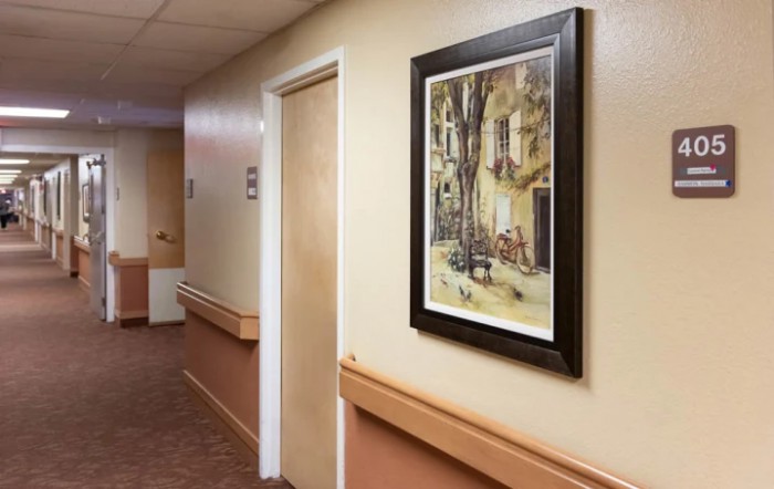 A hallway featuring a framed painting and a closed door.