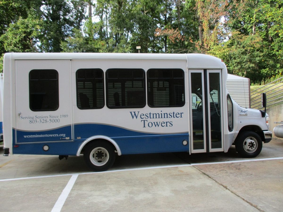 A Westminster Towers shuttle bus parked outdoors.