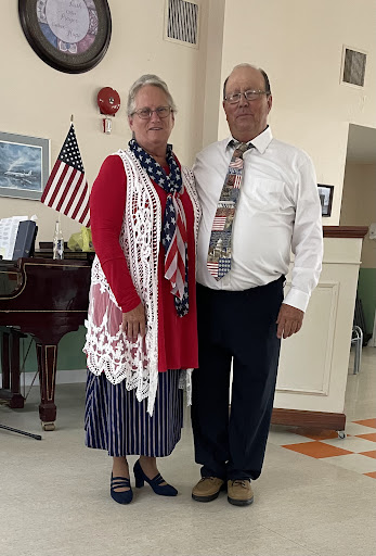 A joyful couple dressed in patriotic attire, celebrating in a festive environment.