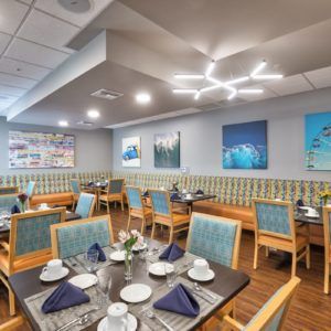A modern restaurant dining area with neatly arranged tables and chairs, featuring contemporary decor and lighting.