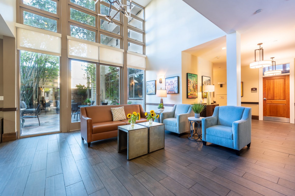 A modern and cozy living room with abundant natural light, featuring comfortable seating and stylish decor.