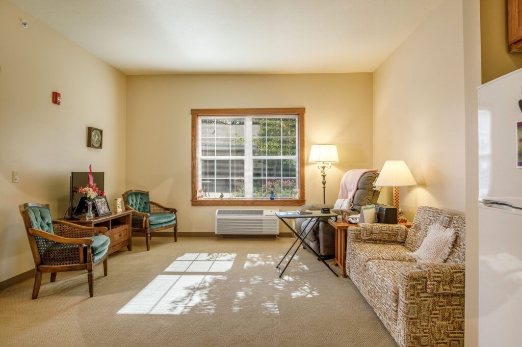 A cozy living room with comfortable seating and natural light streaming in through a large window.