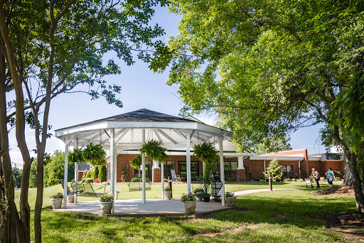 A beautifully designed gazebo surrounded by lush greenery, perfect for outdoor gatherings.