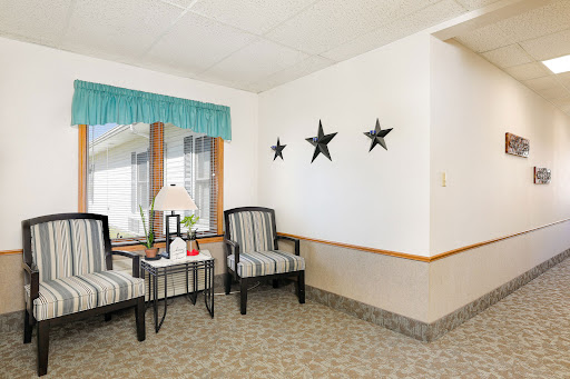 A cozy living room corner featuring striped chairs, a small table, and decorative star accents on the wall.