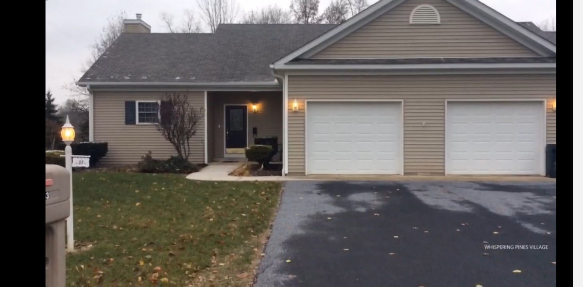 A suburban house with an attached garage and a paved driveway.