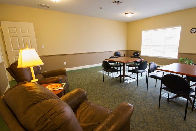 A cozy meeting area with a sofa and table, featuring comfortable seating and warm lighting.