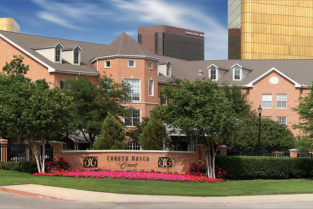 A luxurious residential complex with manicured landscaping and clear blue skies.