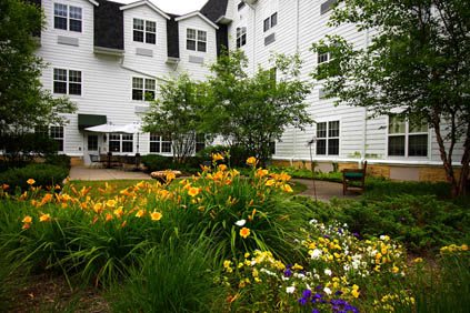 A beautifully landscaped garden in front of a white multi-story building.