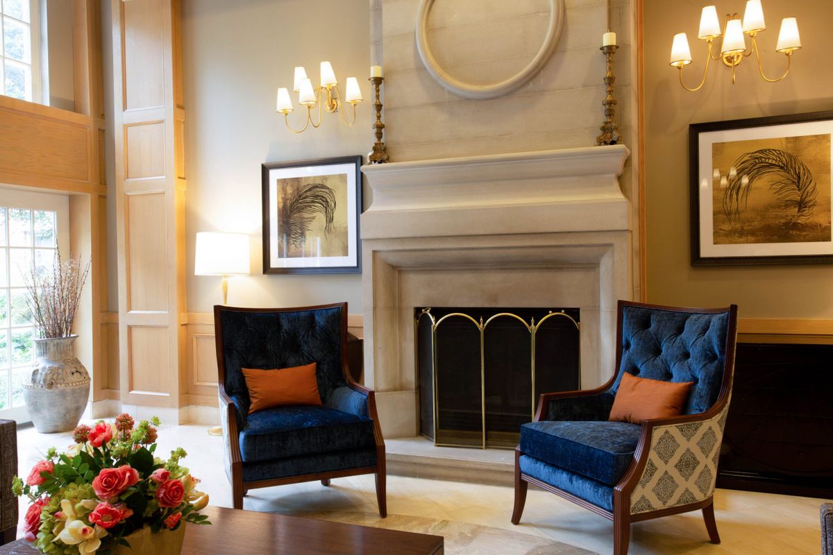 A cozy living room with a fireplace and blue chairs, complemented by modern decor.