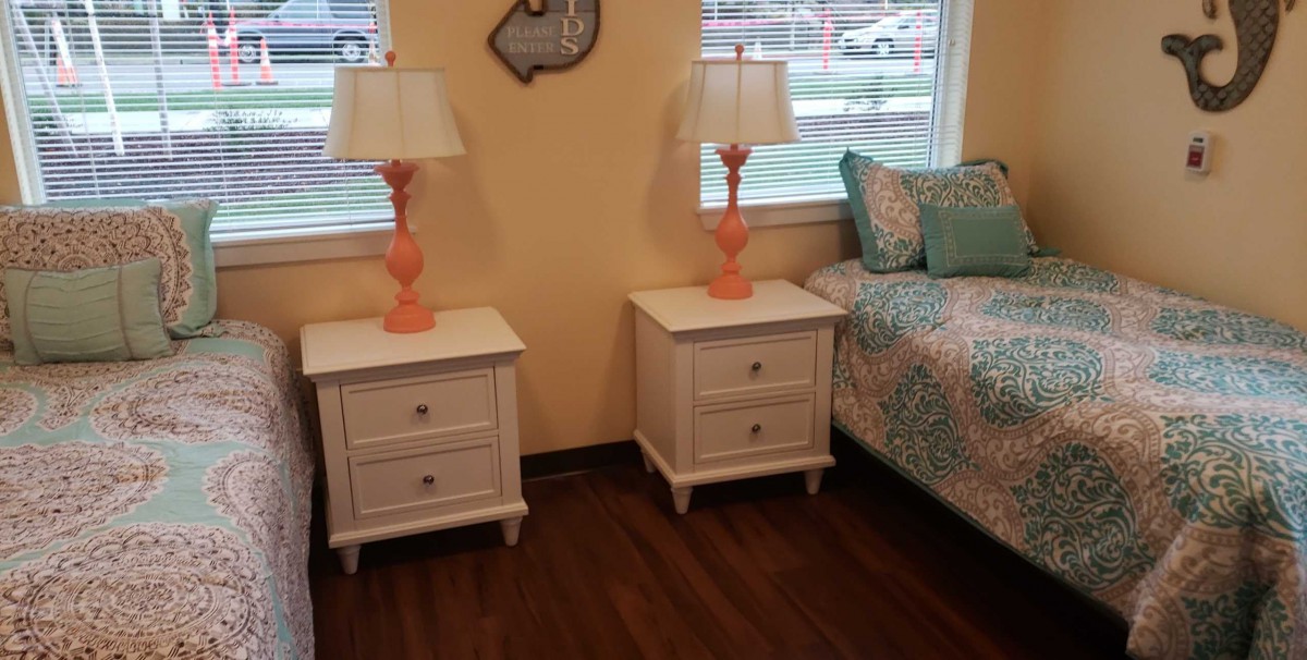 A cozy bedroom with matching nightstands and vibrant lamps.