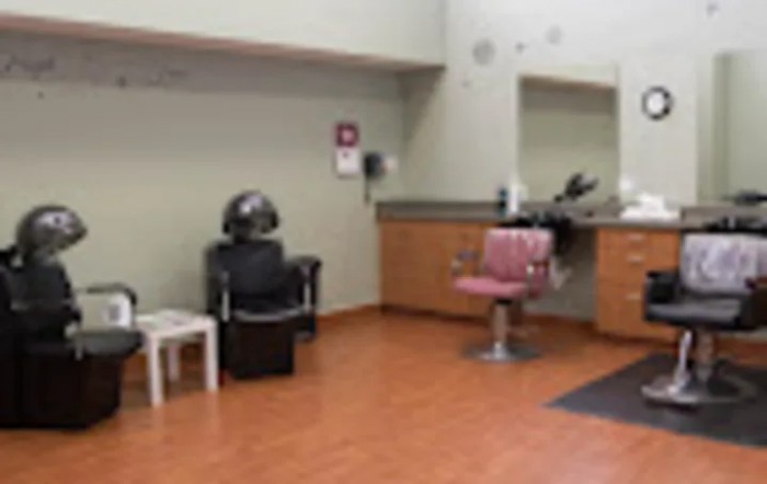 A salon interior featuring a hair styling chair and mirror setup.