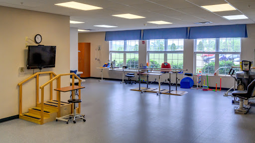 A spacious and well-lit therapy room equipped for rehabilitation services.