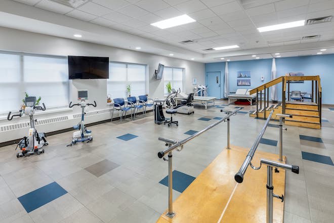 A well-equipped physical therapy and rehabilitation room with various exercise equipment.