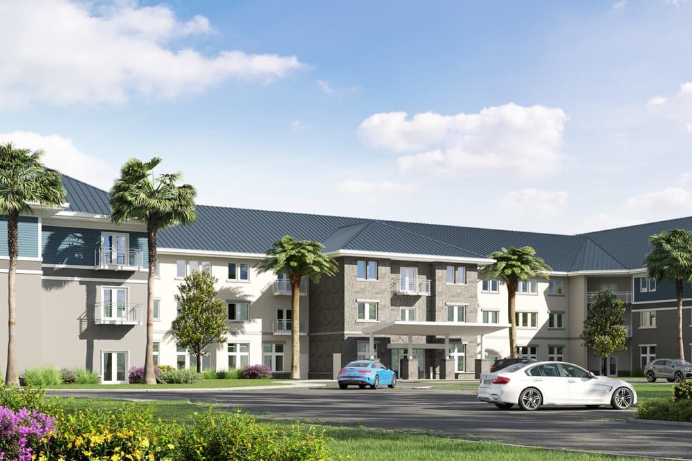 A modern residential building with palm trees and parked cars under a partly cloudy sky.