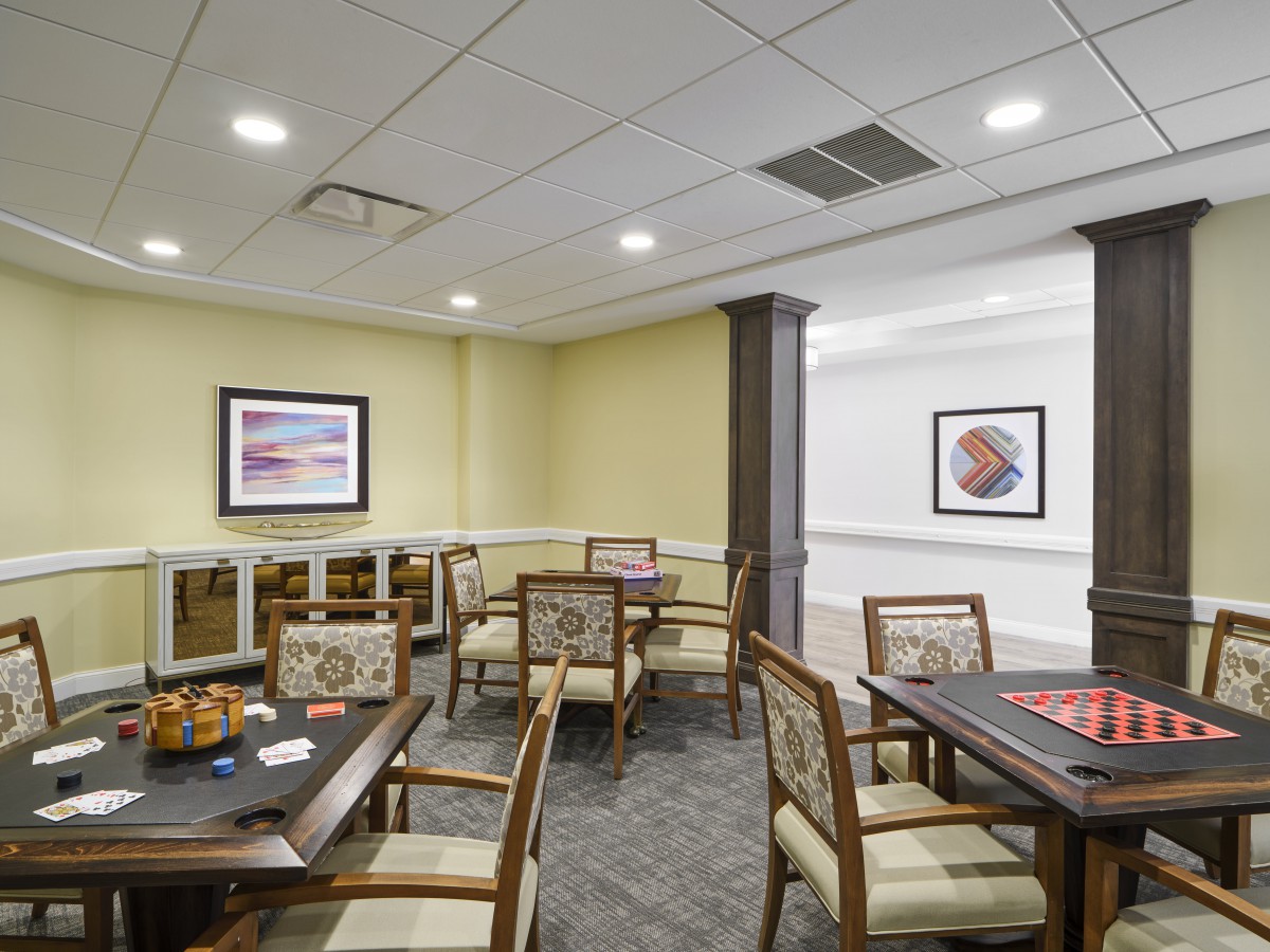 A cozy dining area with several tables and chairs, decorated with artwork on the walls.