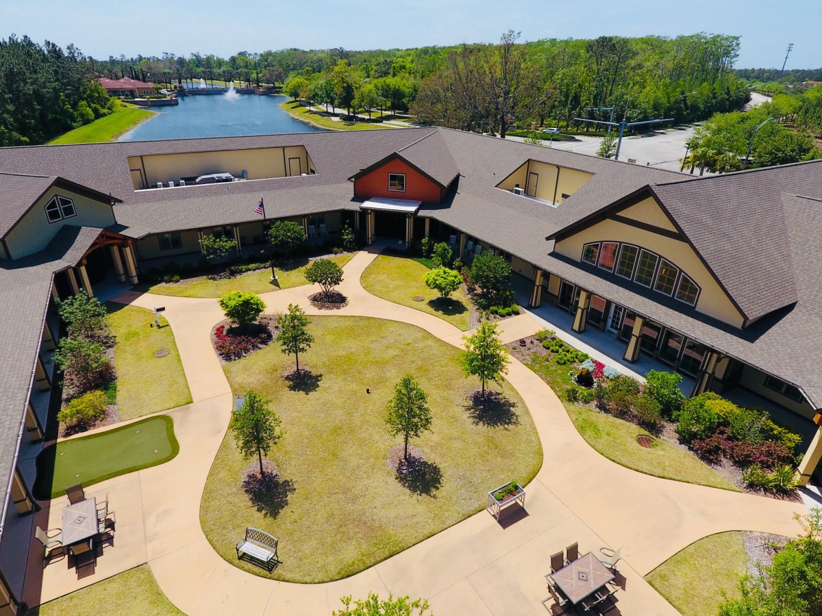 Aerial view of a landscaped courtyard surrounded by a building with scenic greenery and walkways.