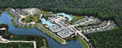 A picturesque aerial view of a resort featuring multiple swimming pools and surrounded by lush greenery.