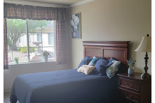 A cozy bedroom featuring a neatly made bed, decorative pillows, and a window with natural light.