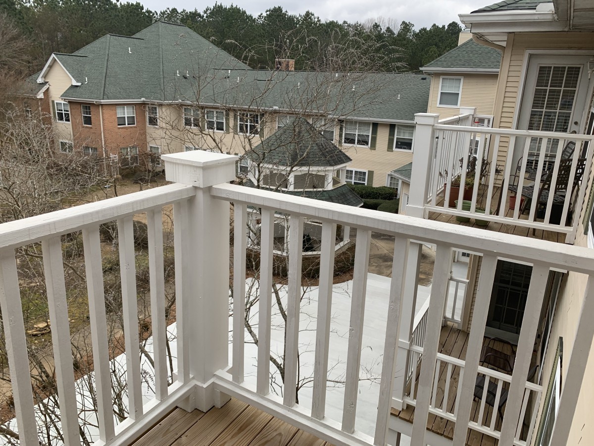 View from a balcony overlooking neighboring rooftops on an overcast day.
