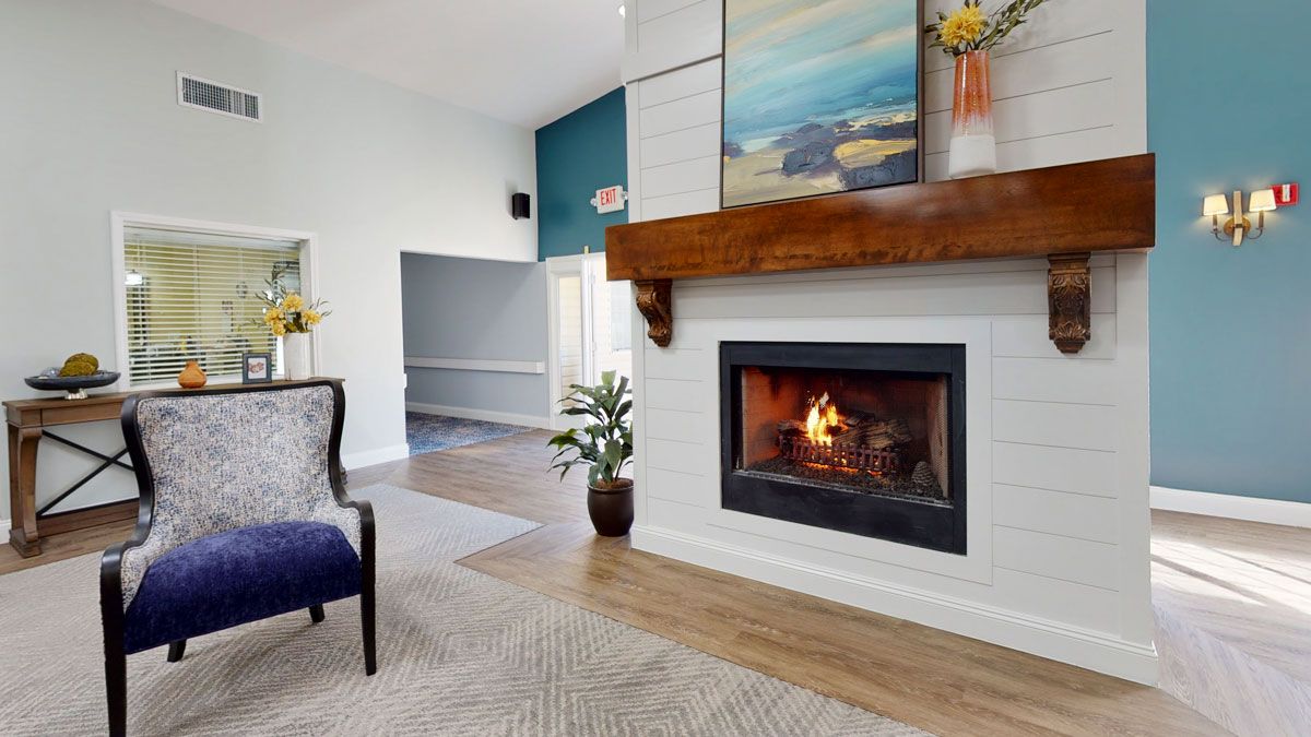 A modern living room featuring a cozy fireplace with artwork above it.