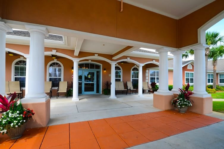 Elegant building entrance with white columns and a covered walkway.