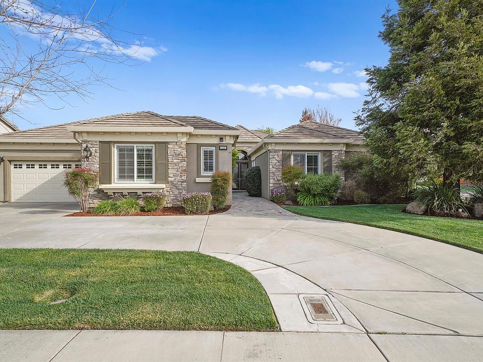 A suburban house with a well-maintained garden and driveway.