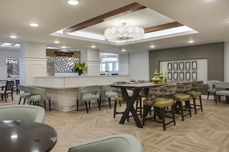A modern kitchen and dining area featuring a central island, stylish bar stools, and a unique lighting fixture.