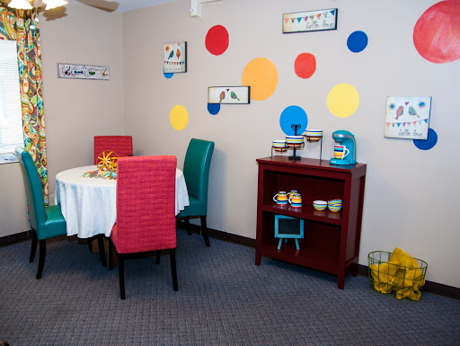 A vibrant dining area featuring colorful chairs and playful wall decor.