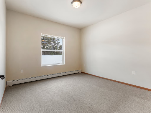 A bright, empty room with a window allowing natural light to fill the space.