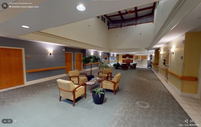 A modern lobby with comfortable seating and plants, featuring warm lighting and a spacious layout.